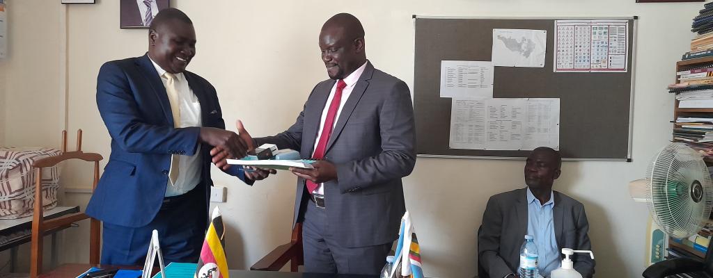 The outgoing Chief Administrative Officer, Mr Oola Donato on the left handing over office to the incoming Chief Administrative Officer Byekwaso Fredrick . NEW CAO
